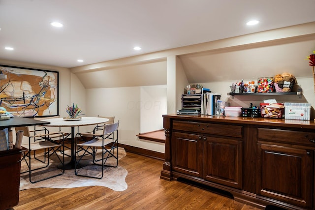 dining space with lofted ceiling and wood-type flooring