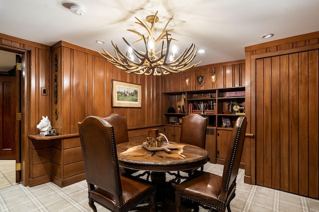 dining room featuring a notable chandelier and wooden walls