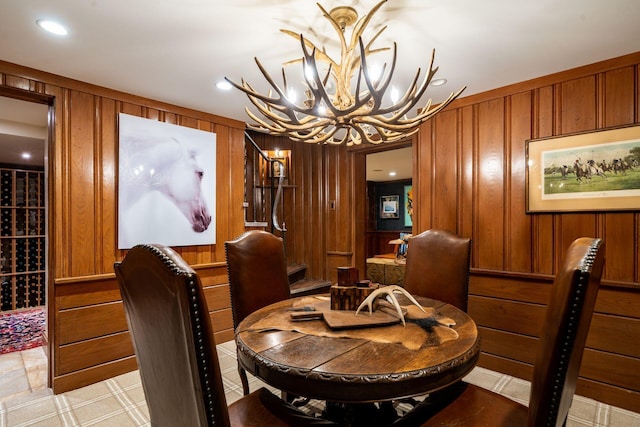 dining space featuring a notable chandelier and wood walls