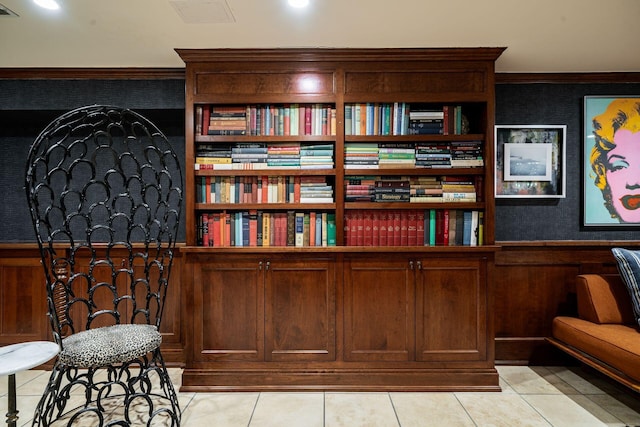 sitting room with crown molding and light tile patterned flooring