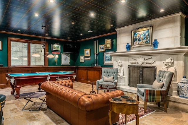 game room with pool table, ornamental molding, and a high end fireplace