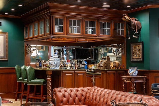 bar featuring crown molding and dark stone counters