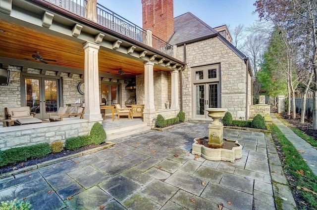 rear view of house with a patio, a balcony, ceiling fan, and french doors