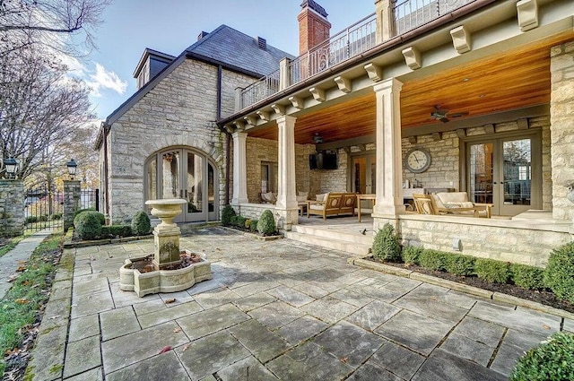 back of house featuring a patio, a balcony, ceiling fan, an outdoor living space, and french doors