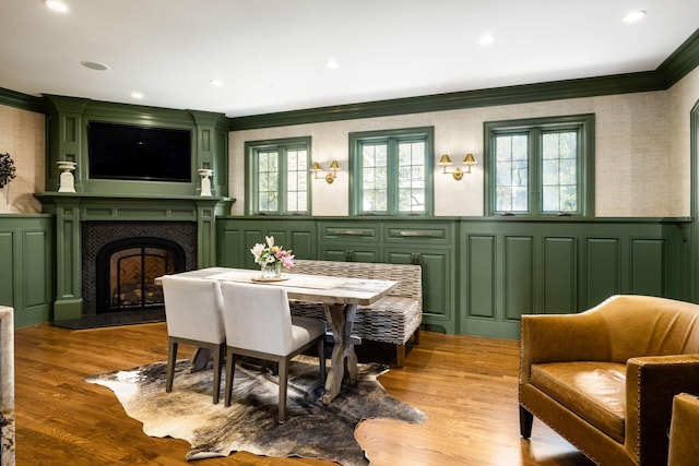 2528 Tremont Rd, Columbus, OH 43221 - dining room featuring ornamental molding, a decorative wall, a large fireplace, wainscoting, and wood finished floors