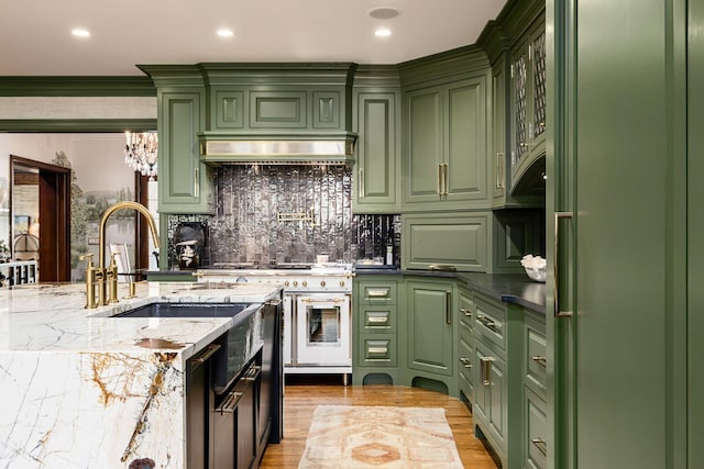 2528 Tremont Rd, Columbus, OH 43221 - kitchen with green cabinets, decorative backsplash, light stone countertops, high end stainless steel range, and light wood-type flooring