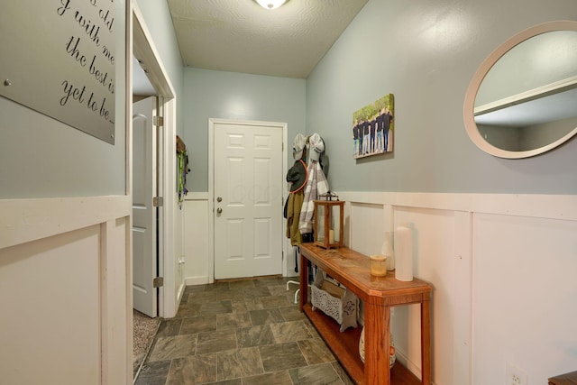 doorway to outside with a textured ceiling