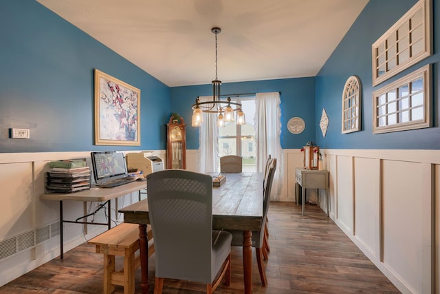 dining area with dark wood-type flooring and a notable chandelier