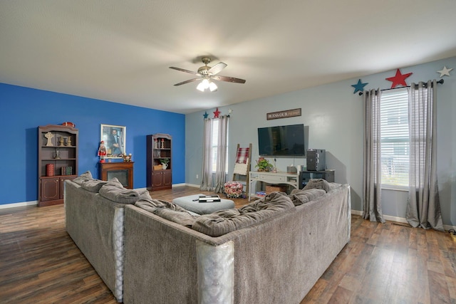 living room with dark hardwood / wood-style flooring and ceiling fan