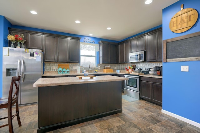 kitchen featuring a kitchen island, appliances with stainless steel finishes, and dark brown cabinetry