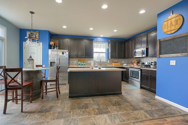 kitchen featuring hanging light fixtures, dark brown cabinets, and stainless steel appliances