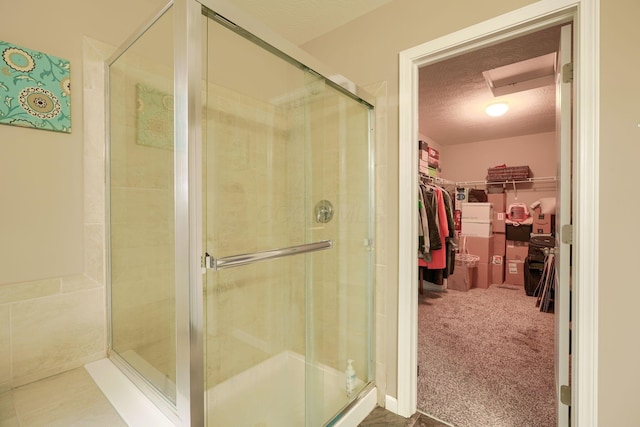 bathroom featuring an enclosed shower and a textured ceiling