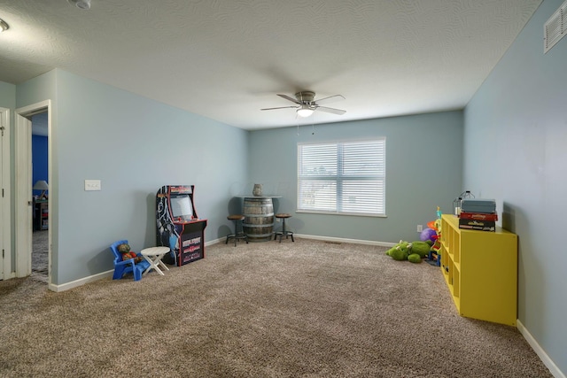 playroom with ceiling fan, carpet, and a textured ceiling