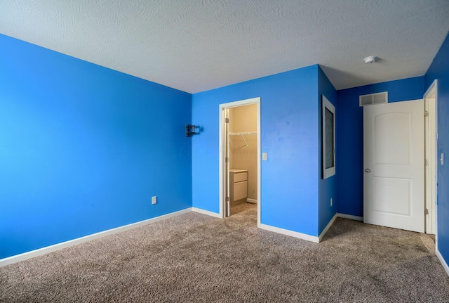 unfurnished bedroom with a closet, a textured ceiling, and carpet flooring