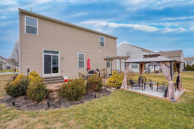 rear view of property featuring a gazebo, a lawn, and a patio