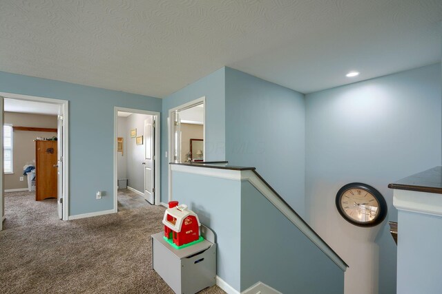 corridor featuring carpet and a textured ceiling