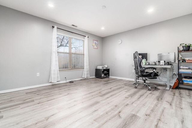 home office with light hardwood / wood-style floors