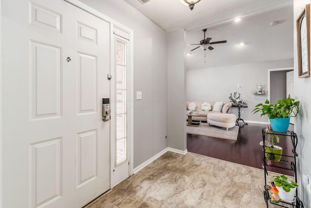 foyer with ceiling fan and lofted ceiling