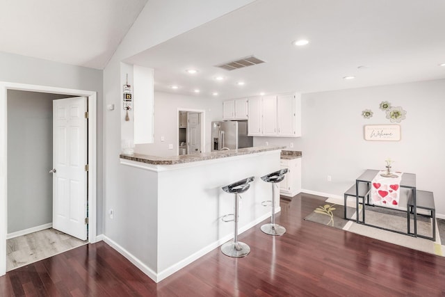 kitchen featuring white cabinetry, hardwood / wood-style flooring, kitchen peninsula, and stainless steel refrigerator with ice dispenser