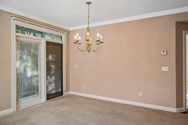 spare room featuring ornamental molding, carpet flooring, and a chandelier