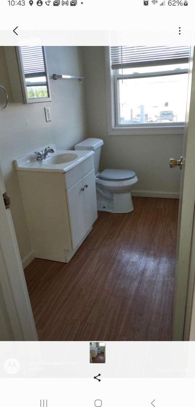 bathroom with vanity, toilet, hardwood / wood-style floors, and plenty of natural light