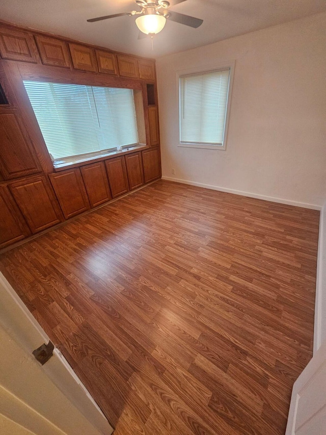 empty room with ceiling fan and wood-type flooring