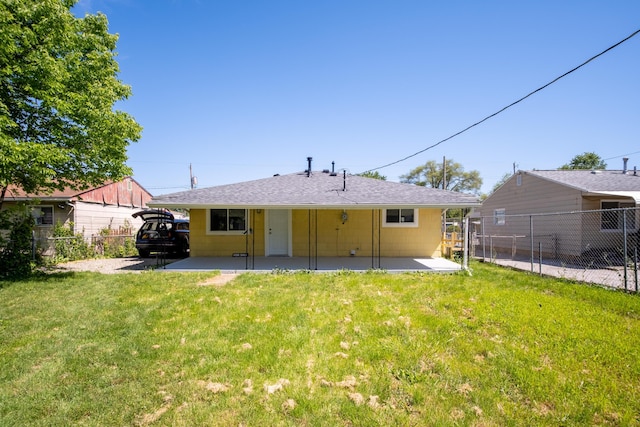 back of house featuring a patio area and a lawn