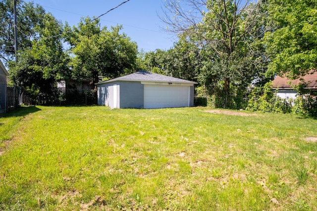 view of yard with a garage and an outbuilding