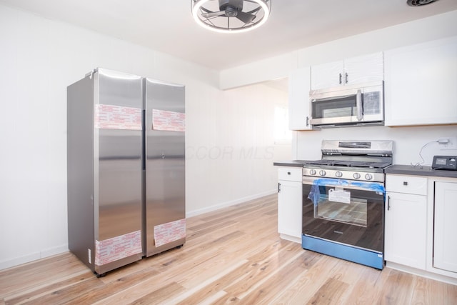 kitchen featuring stainless steel appliances, white cabinetry, ceiling fan, and light hardwood / wood-style flooring