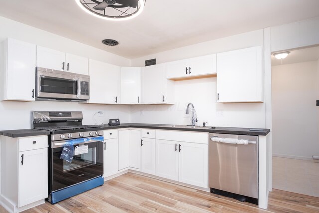 kitchen with white cabinetry, sink, stainless steel appliances, and light hardwood / wood-style floors