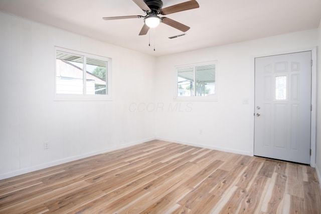 spare room featuring plenty of natural light, light hardwood / wood-style floors, and ceiling fan