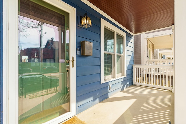 view of exterior entry featuring covered porch