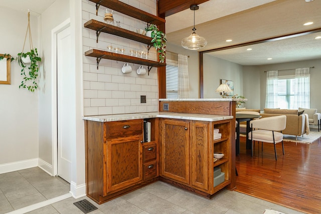 bar featuring tasteful backsplash, hanging light fixtures, and light tile patterned floors