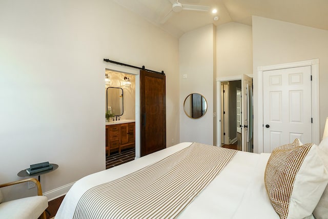 bedroom with lofted ceiling, a barn door, and ensuite bathroom