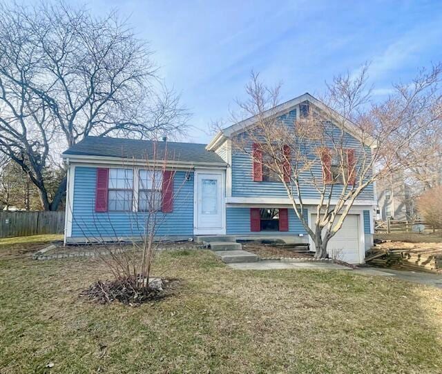 tri-level home featuring a garage and a front yard