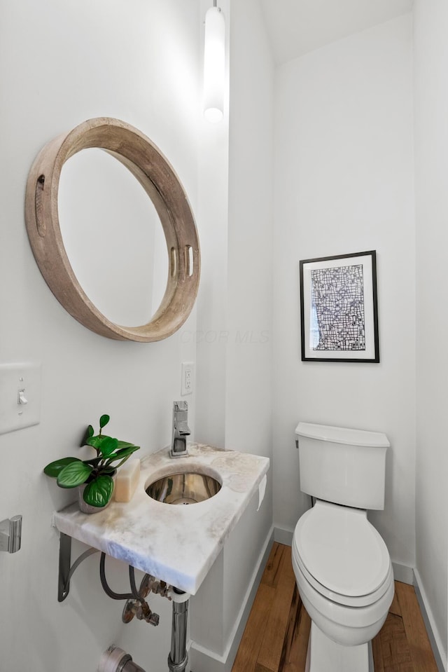 bathroom with wood-type flooring, sink, and toilet