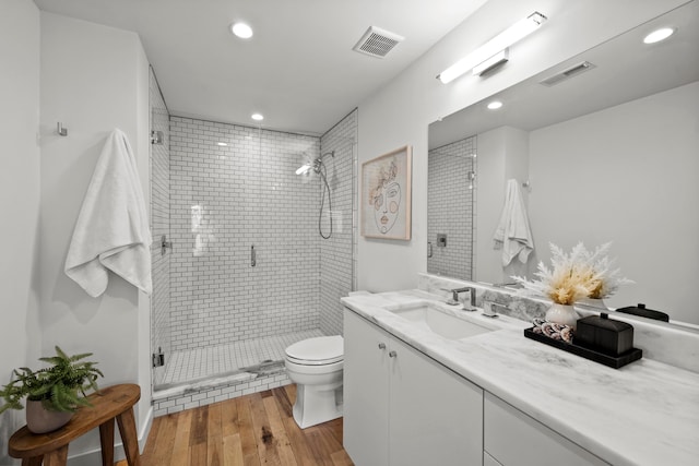 bathroom featuring hardwood / wood-style flooring, vanity, toilet, and walk in shower