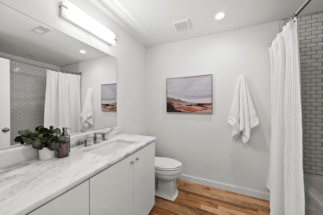 bathroom with hardwood / wood-style flooring, vanity, and toilet