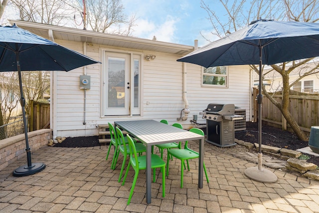 view of patio featuring outdoor dining area, fence, and grilling area