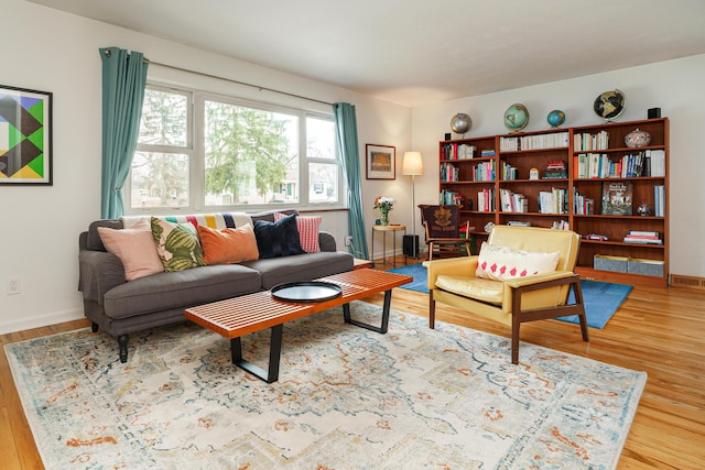 living area with baseboards and wood finished floors