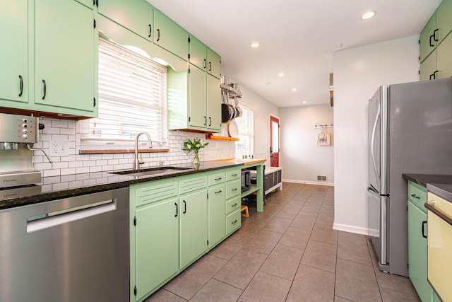 kitchen with light tile patterned floors, decorative backsplash, appliances with stainless steel finishes, a sink, and recessed lighting