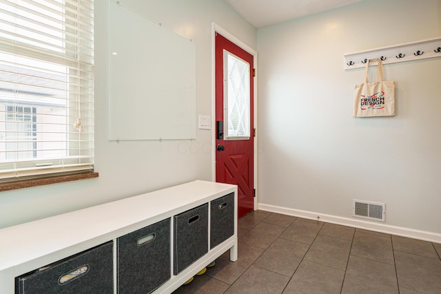 mudroom with dark tile patterned flooring, visible vents, and baseboards