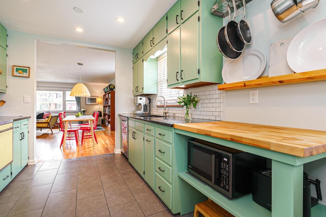 kitchen featuring green cabinetry, backsplash, dark tile patterned floors, a sink, and recessed lighting