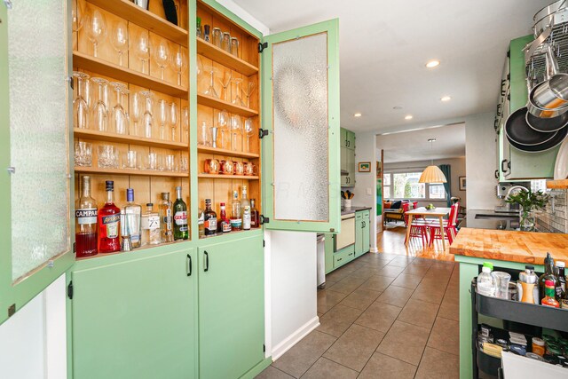 bar with a bar, recessed lighting, and tile patterned floors