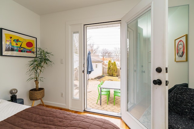 interior space with access to outside, wood finished floors, and baseboards