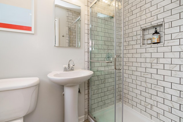 bathroom with a shower stall and toilet