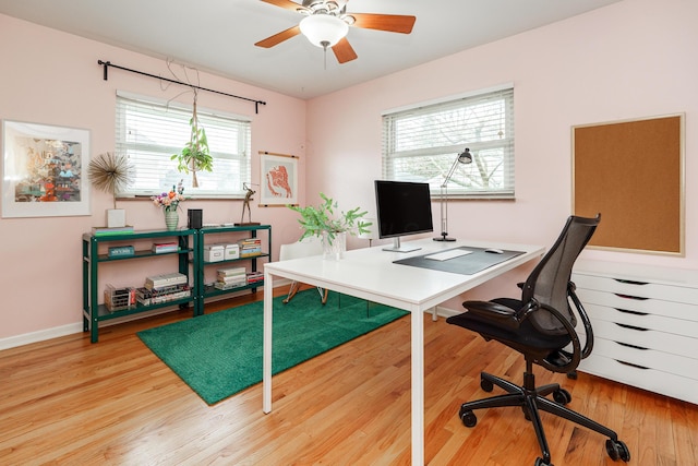 home office featuring wood finished floors, a ceiling fan, and baseboards