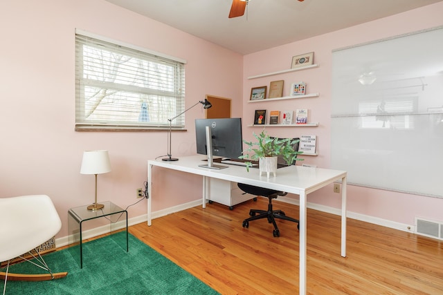 office area with visible vents, ceiling fan, baseboards, and wood finished floors