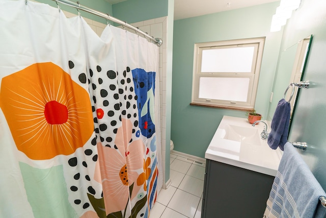 bathroom featuring toilet, a shower with shower curtain, vanity, baseboards, and tile patterned floors