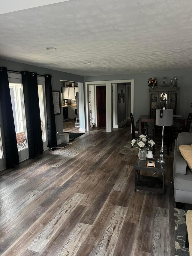 unfurnished living room featuring dark wood-style floors and a textured ceiling